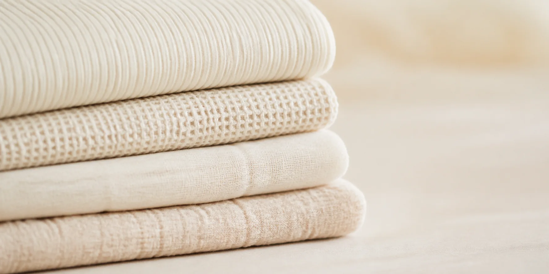 Layers of soft cream cotton, waffle knit, and muslin fabric